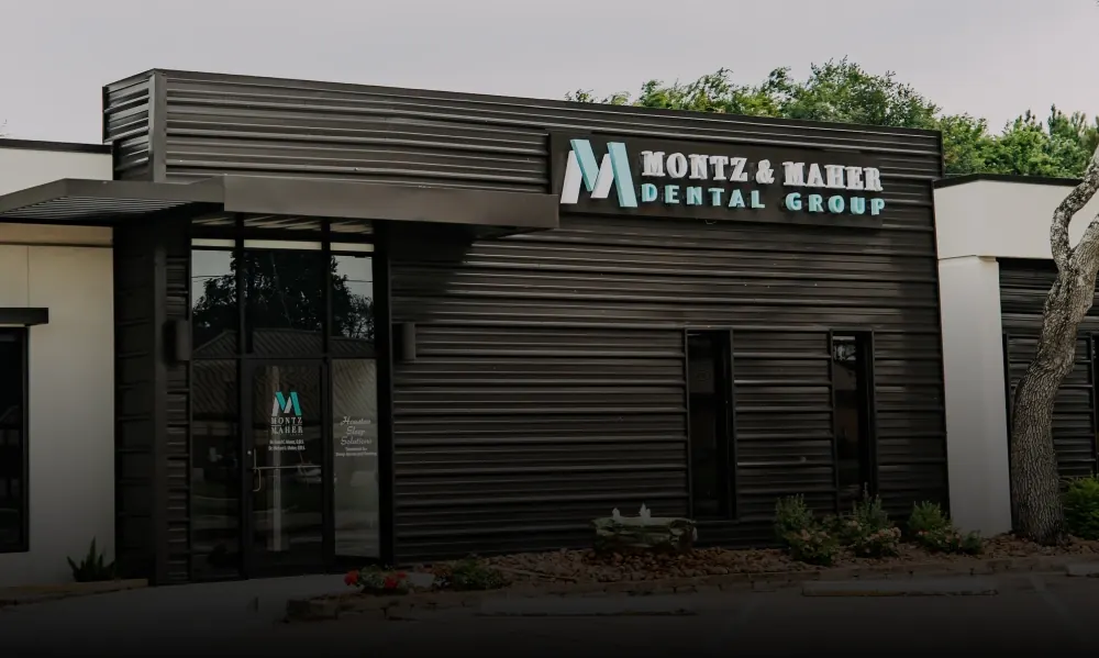 The Montz & Maher Pearland office on Galveston Avenue, dark timber cladding with the practice name in lights.